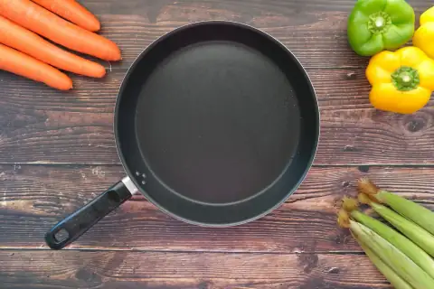 Tawa: black round plate on brown wooden table