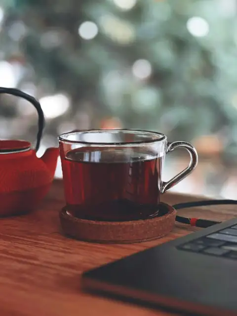 Mugs, cups & glasses: a cup of tea next to a laptop computer