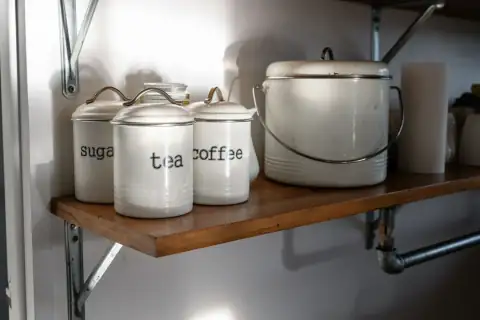 Containers & jars: White canisters labeled sugar, tea, and coffee on shelf