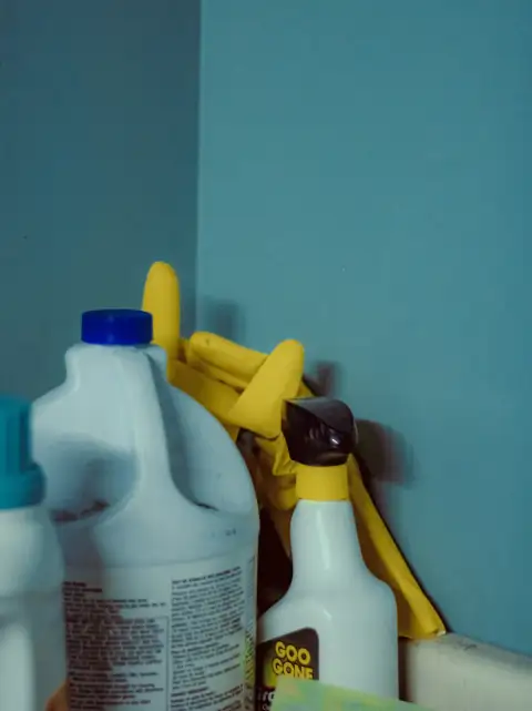 Phenyl & cleaners: A close up of a bottle of cleaner next to a mirror