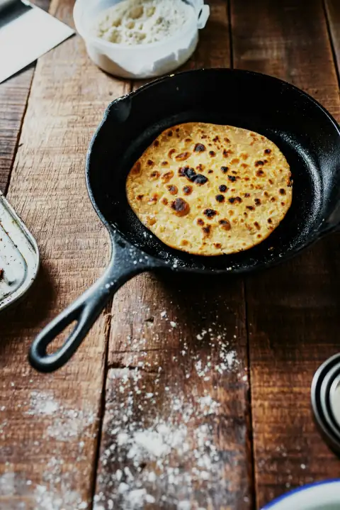 Tawa: black frying pan on brown wooden table