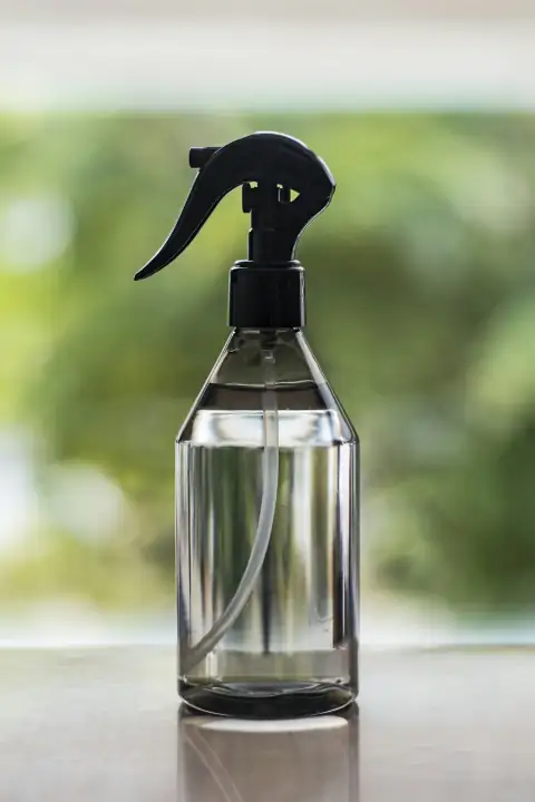 Spray bottles: a spray bottle on a table with a blurry background