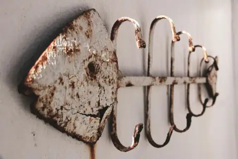 Hooks: a rusted metal hook on a white wall