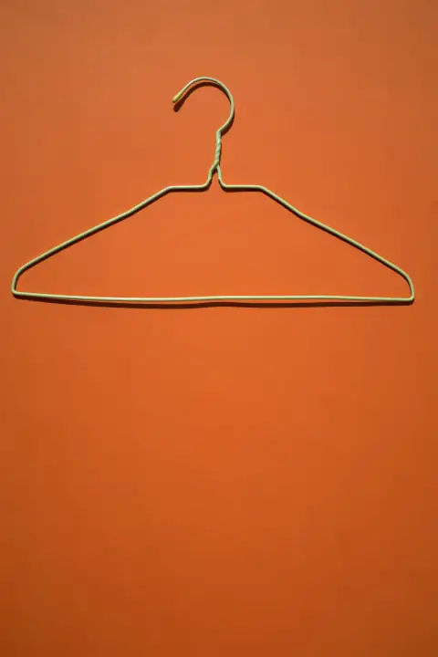 Hangers & clips: white clothes hanger on orange flooring