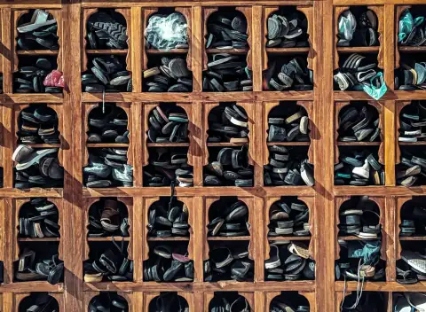 Shoe racks: A wooden shelf filled with lots of shoes