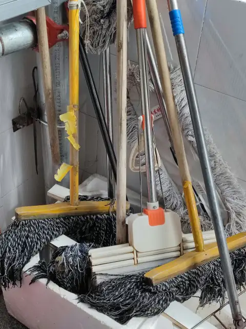 Floor wipers: white plastic bucket on brown wooden ladder