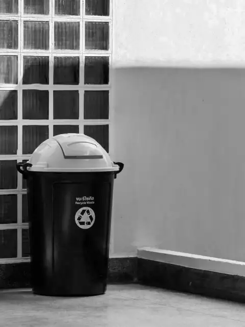 Dustbins: A black trash can with a recycling symbol