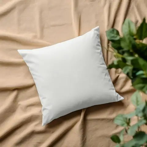 Pillows: a white pillow sitting on top of a bed next to a plant