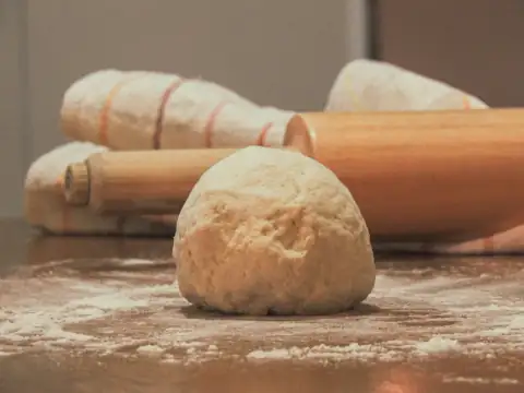 Chakla & belan: white dough on brown wooden table