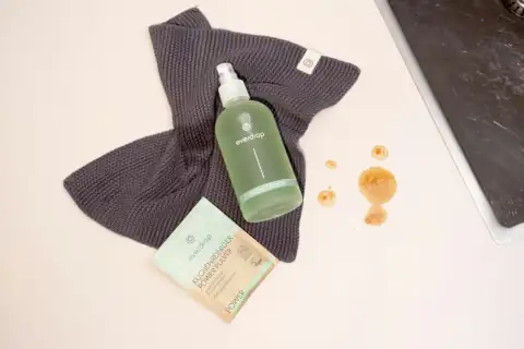 Phenyl & cleaners: a bottle of water next to a cloth and a laptop