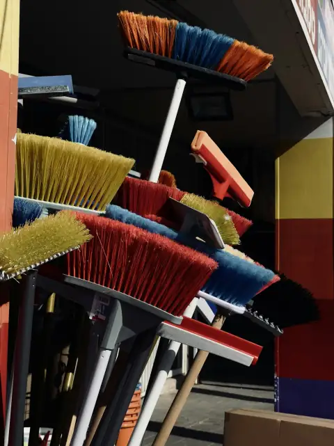 Brooms: a bunch of brooms that are outside of a building