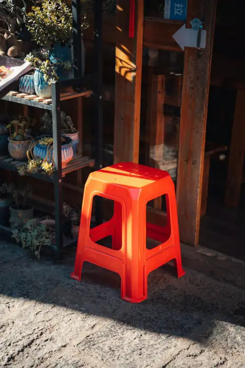 Stools & chairs: A bright orange plastic stool sits outdoors