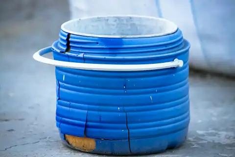 Buckets: A damaged blue plastic barrel with a white handle
