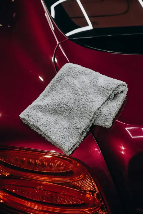 Dusters: Gray microfiber cloth resting on a red car