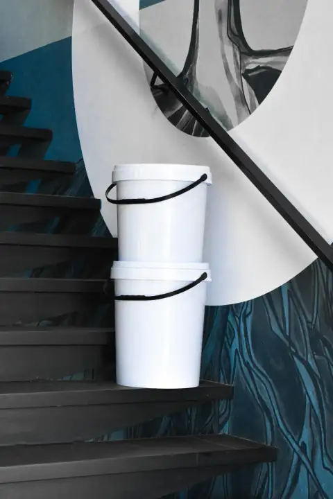 Buckets: a white bucket sitting on top of a set of stairs