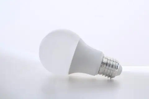 Bulbs & batteries: a white light bulb sitting on top of a white table