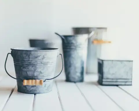 Buckets: gray steel bucket on brown wooden bucket