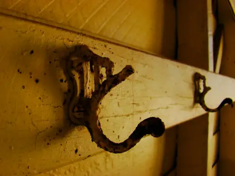 Hooks: An old, rusted hook hangs on a weathered wall