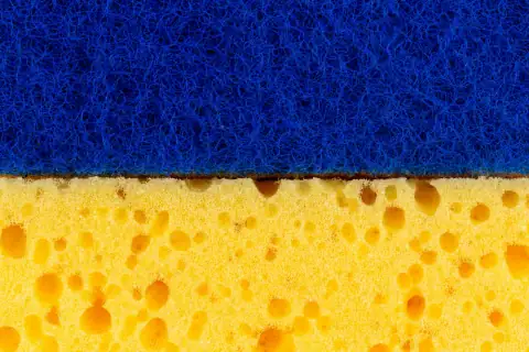 Scrubbers & sponges: a close up of a sponge on a blue and yellow surface
