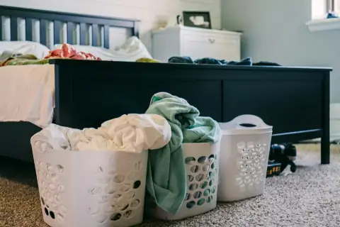 Baskets: three laundry baskets sitting on the floor next to a bed