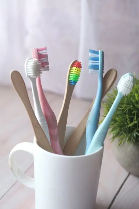 Combs & grooming: white and blue toothbrush in white ceramic mug