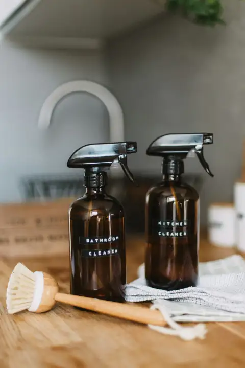 Phenyl & cleaners: two brown spray bottles on brown table